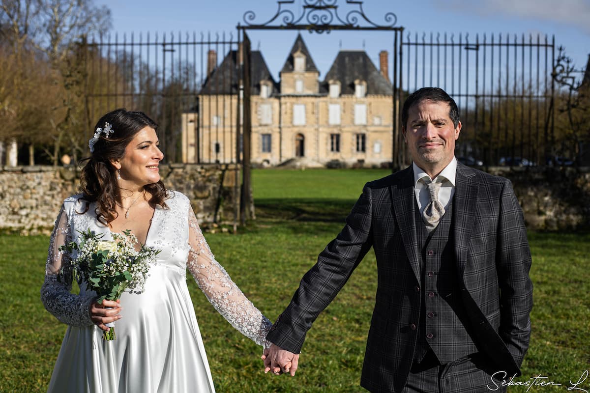Mariés main dans la main devant un château